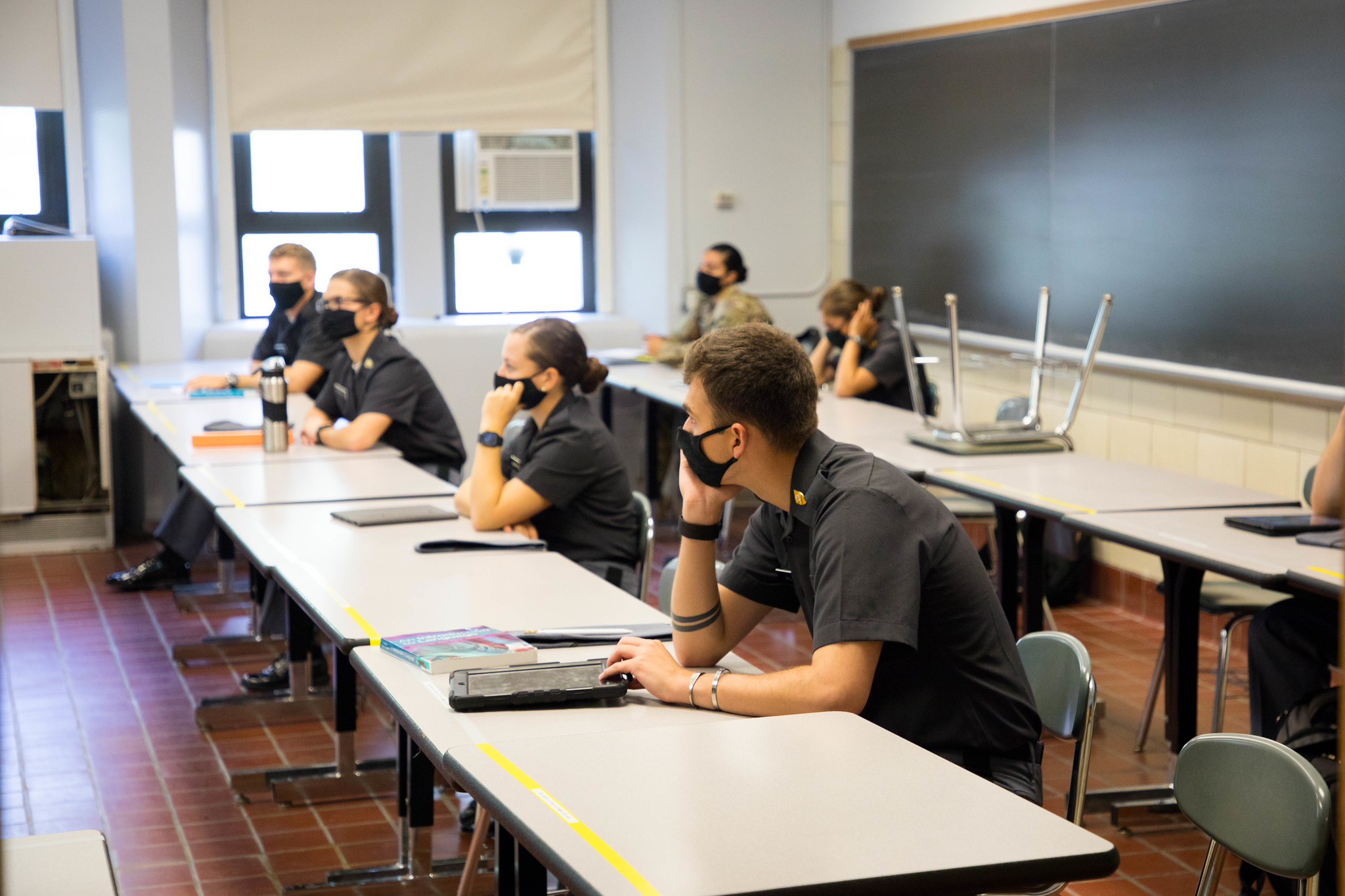 students with masks sitting 6 feet apart in a clssroom