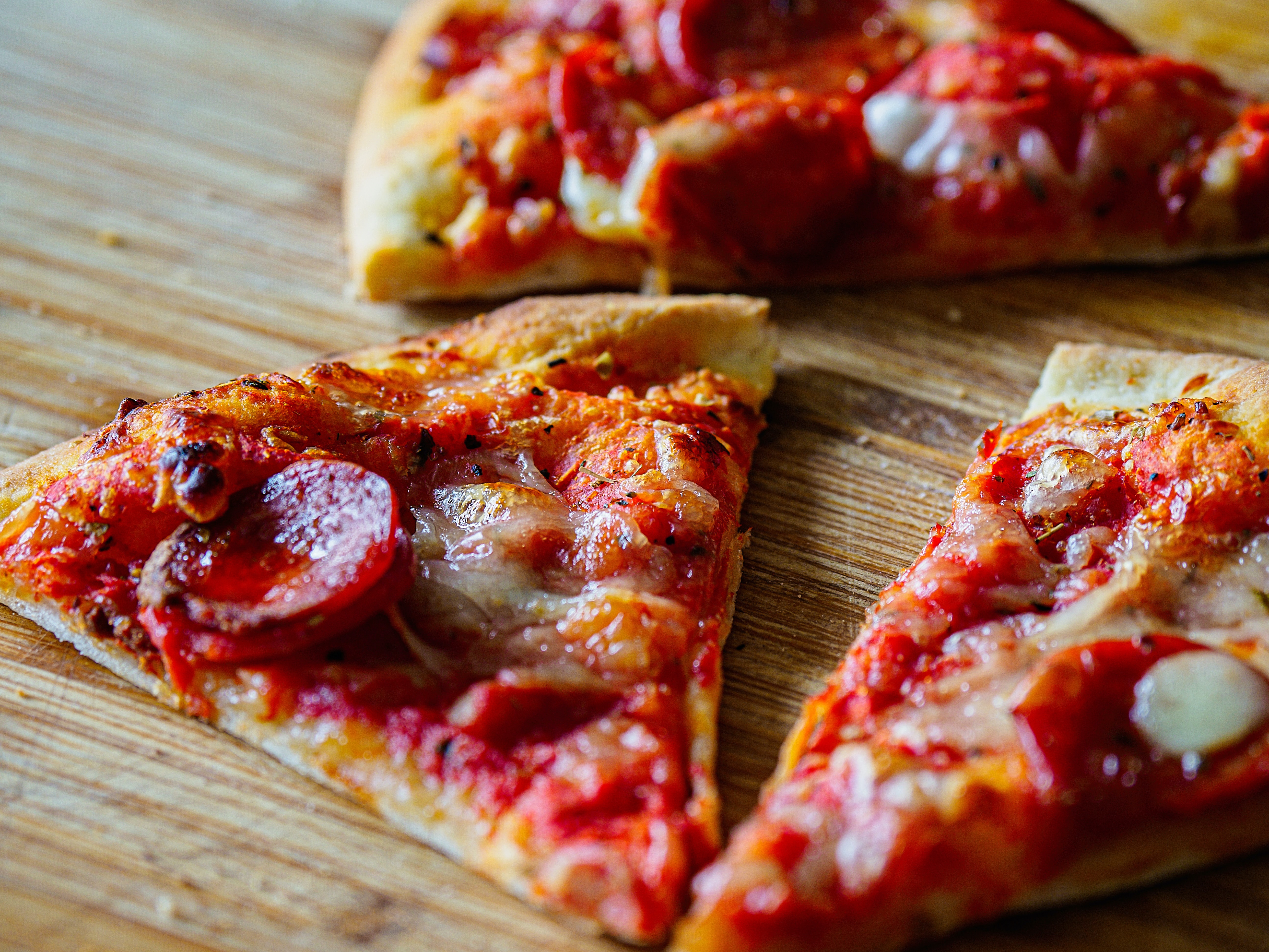 sliced pizza on brown wooden table